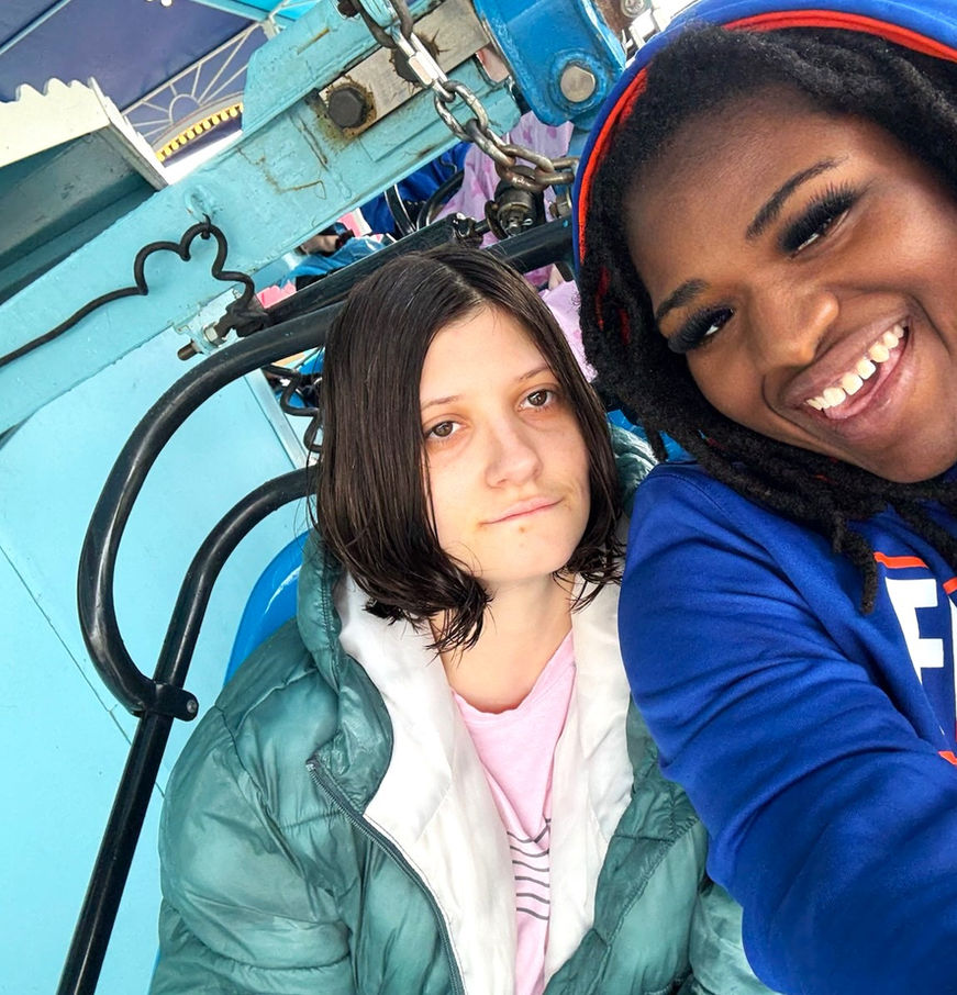Two women on a ride, one smiling at the camera