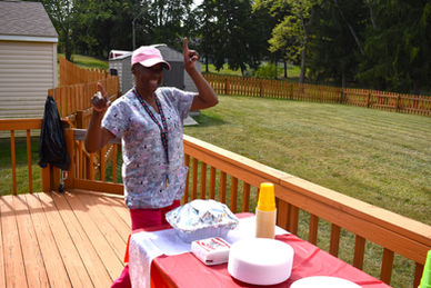 Person standing by picnic table in backyard.