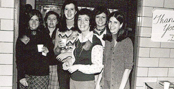 Seven women in a doorway with a 'Thank You!' sign