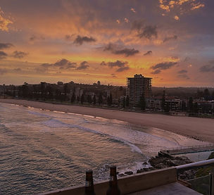 Vista de la playa y el skyline de Sídney al atardecer en Australia
