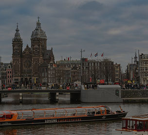 Ferry navegando por uno de los canales de Ámsterdam con edificios históricos alrededor