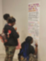Attendees writing on one of the posters.