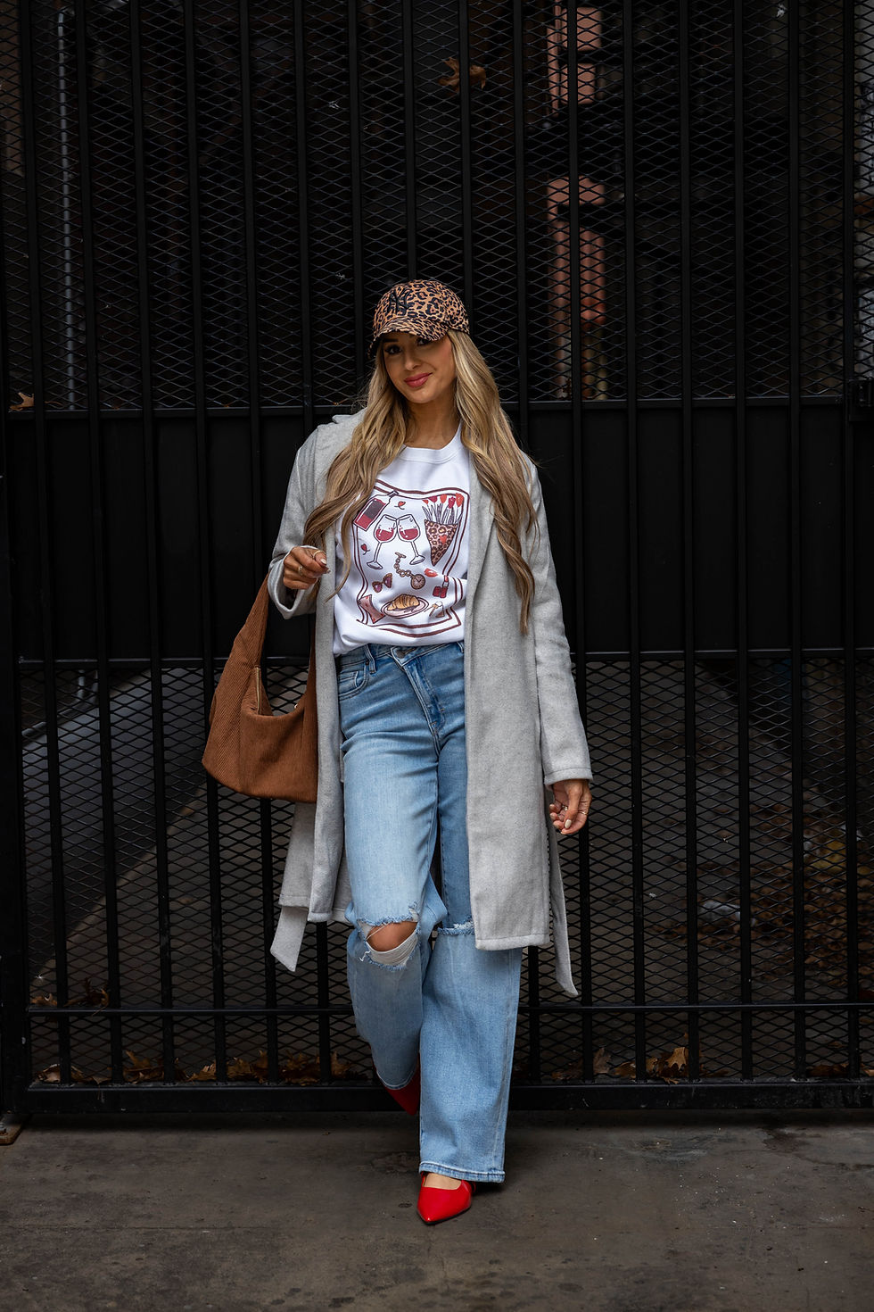 Thumbnail: Alt text: Full view of woman wearing Date Night sweatshirt with jeans, leopard print cap, and grey coat, styled for wine nigh