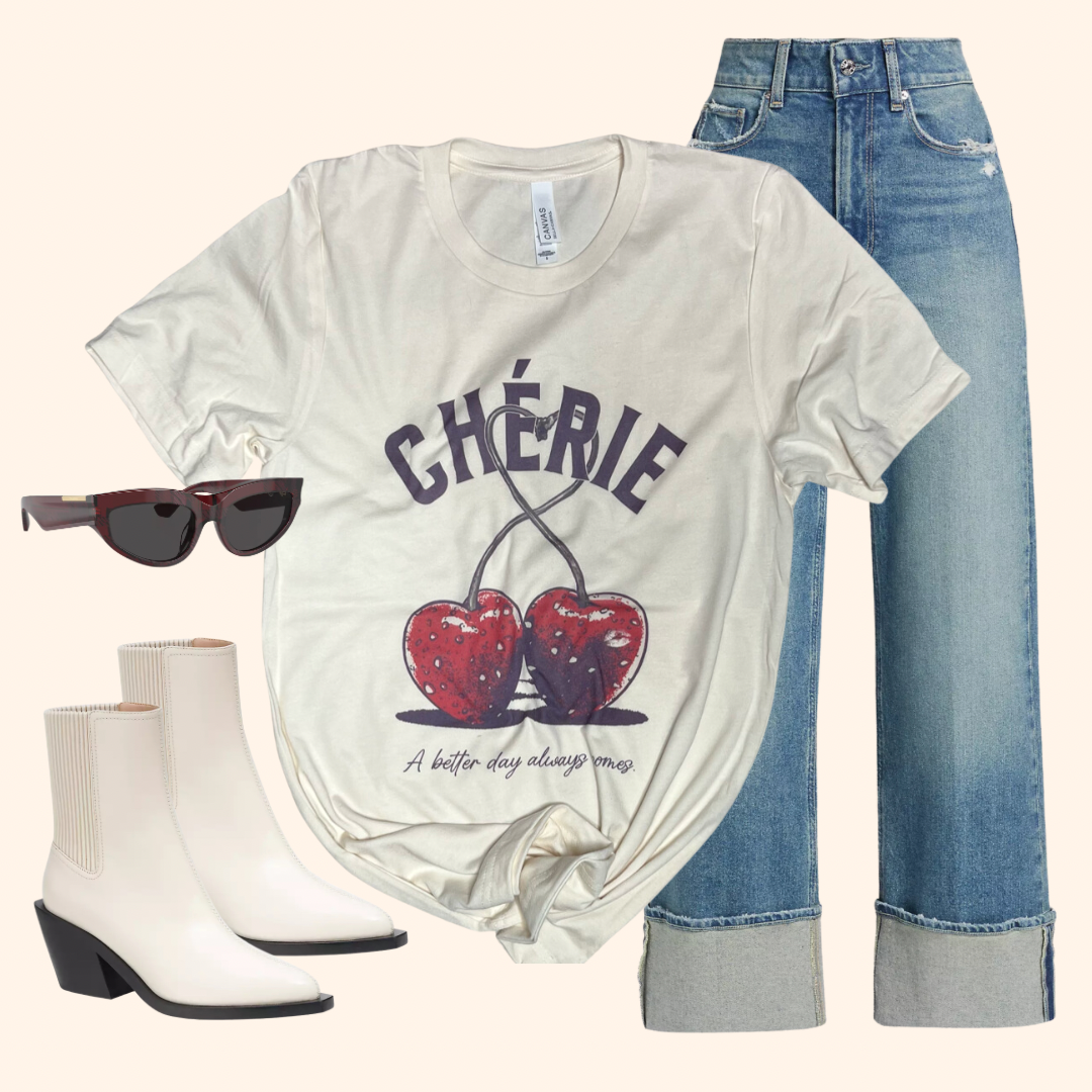 Cherie graphic t-shirt styled with wide cuff jeans, white boots, and sunglasses in a flat lay outfit layout on neutral backgr