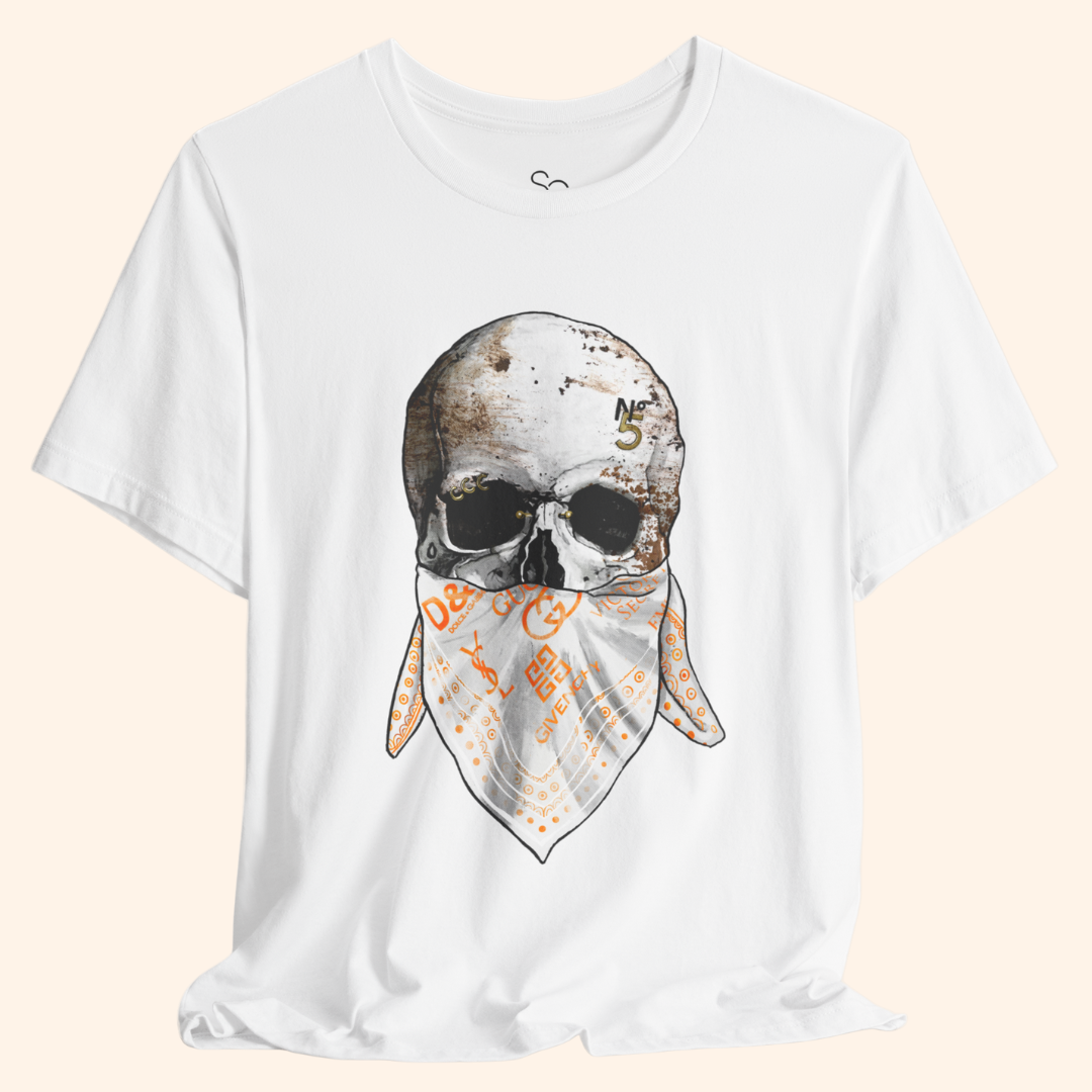 Close-up of All or Nothing skull print with orange accents on white cotton.