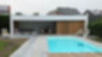 Poolhouse in witte panelen met muren in thermowood ayous en terrastegels met aparte bergruimte.
