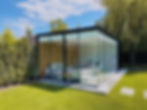Modern poolhouse uit glas en zwarte dakranden. De binnenmuren zijn afgewerkt in hout en witte panelen.