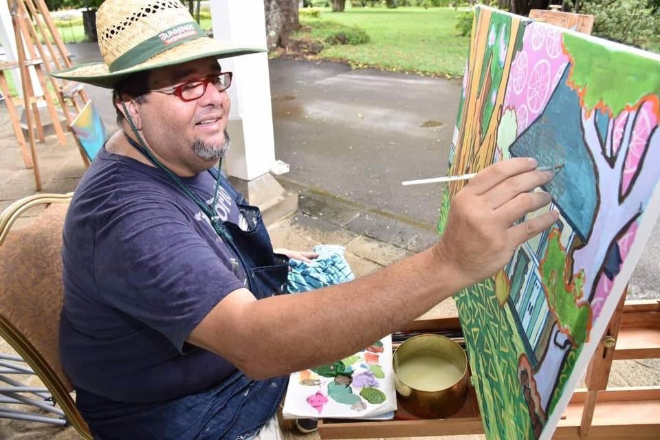 Mauritian artist Pascal Lagesse painting on site at Pamplemousses gardens