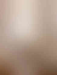 A boutique hotel bedroom in Dubrovnik featuring stone walls and an elegant chandelier.