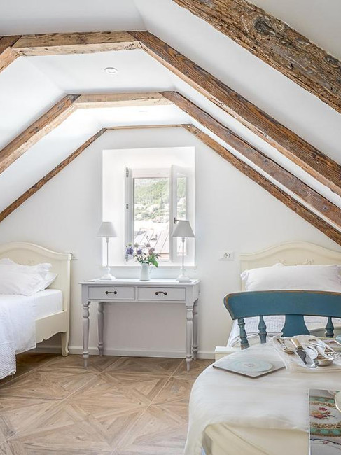 A cozy bedroom at The Byron hotel in Dubrovnik featuring two beds and a small table.