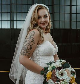 smiling bride holding bouquet wearing veil