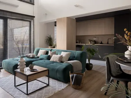 Modern luxury interior design in a compact Singapore home featuring a teal sofa, wooden finishes, natural light, and sleek open-plan living space.