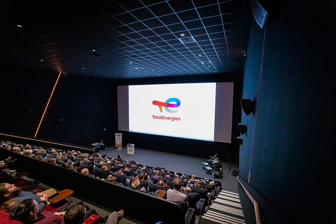 Professional London corporate event photographer capturing a high-impact keynote presentation at a major city conference, featuring a large screen and a focused professional audience.