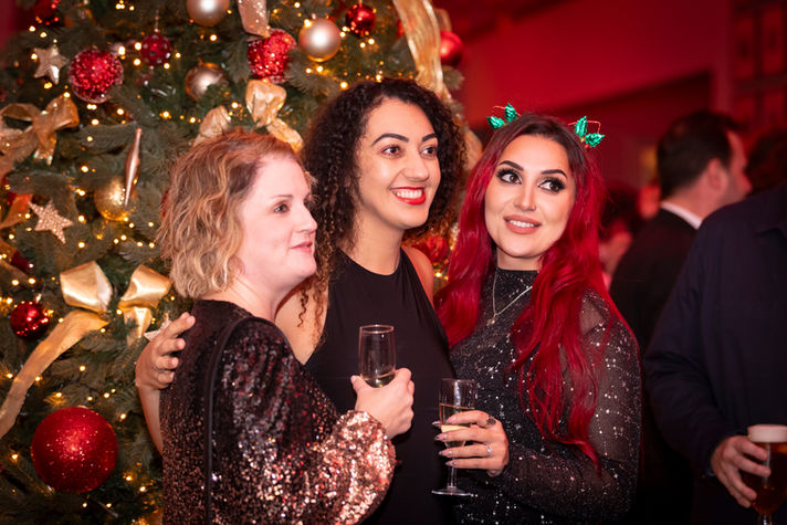 Corporate party photo next to Christmas tree