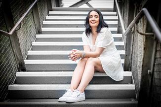 woman in white dress sitting outside on some steps