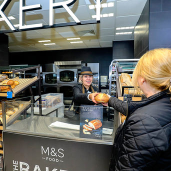 woman buying bread over the shop counter