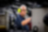 Factory worker operating machinery wearing ear defenders