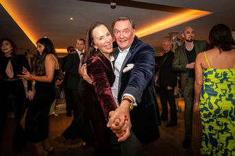 couple dancing hand in hand at black tie event