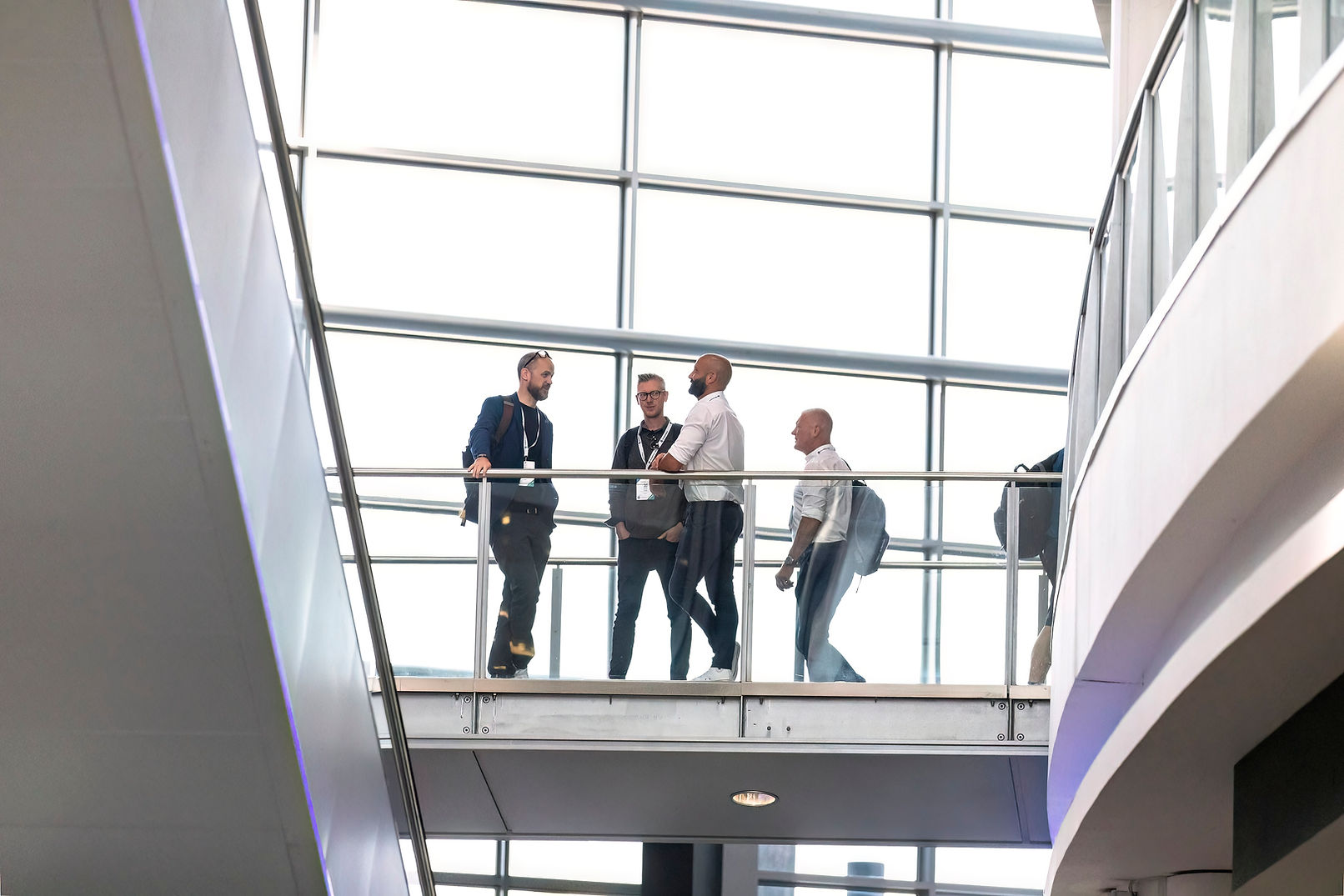 Four business people discussing on a modern building walkway in Leeds