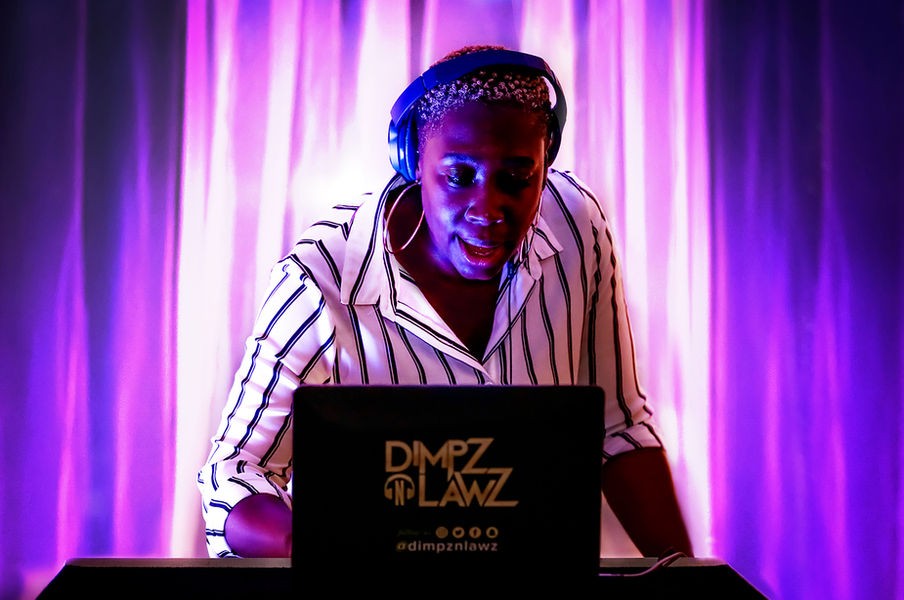 woman DJ with headphones playing music from a laptop