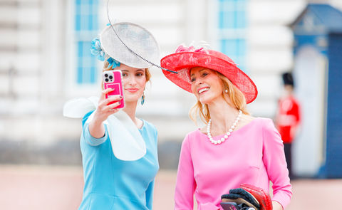 woman in dresses and hats take a selfie