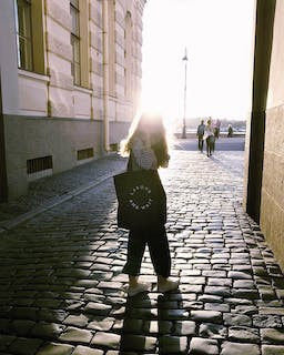 Girl in the sun on a cobble street starting off day with a morning walk or stroll