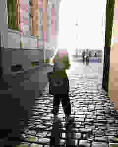 Girl in the sun on a cobble street starting off day with a morning walk or stroll