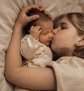 Newbornshoot Zutphen- intieme detailfoto van zus en baby bij natuurlijk licht