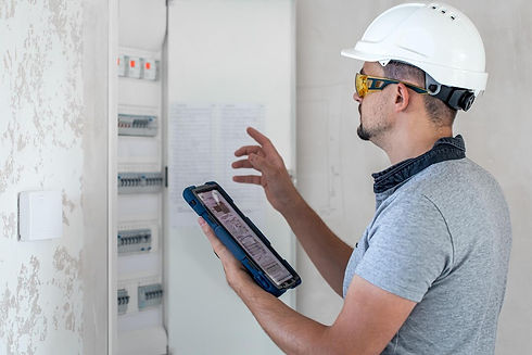 electrical-technician-looking-focused-while-working-switchboard-with-fuses_169016-23483.jp