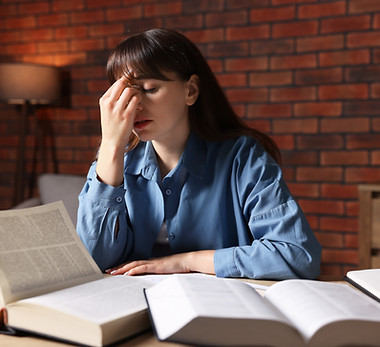 stressed-young-woman-rubbing-her-eyes-while-studyi-2026-05-12-17-10-22-utc.jpg