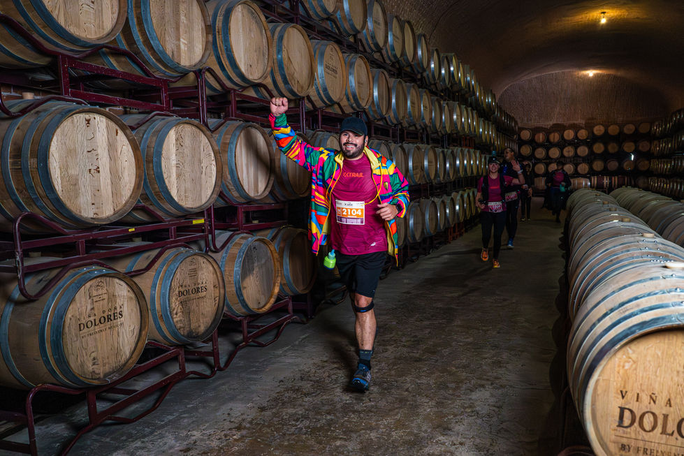 Hombre sonriente con los brazos arriba en bodega con barriles; Xtrail Viñedos 2025 Catiri Media