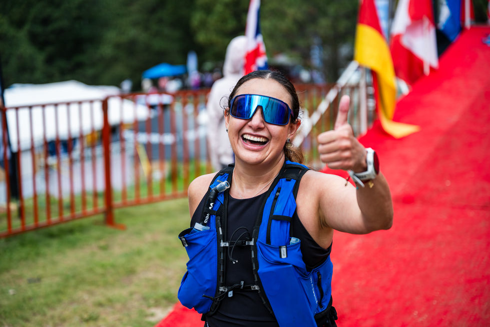 Atleta sonriente con gafas de sol da pulgar arriba, Xtrail Viñedos 2024 en evento.