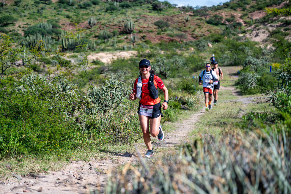 Corredores corren por un sendero montañoso; Gran Fondo Whistler Riviera Nayarit 2025; naturaleza exuberante.