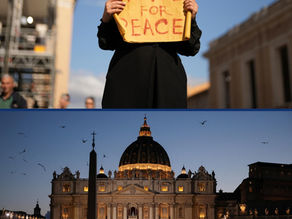 Yona Tukuser holds a "HOPE FOR PEACE" sign in St. Peter's Square at the Vatican during the Conclave