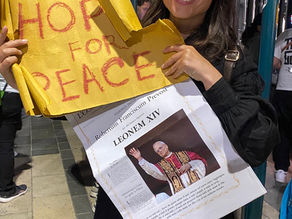 Yona Tukuser holds a "HOPE FOR PEACE" sign in St. Peter's Square at the Vatican during the Conclave