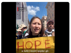 Yona Tukuser holds a "HOPE FOR PEACE" sign in St. Peter's Square at the Vatican during the Conclave