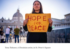 Yona Tukuser holds a "HOPE FOR PEACE" sign in St. Peter's Square at the Vatican during the Conclave