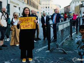 Yona Tukuser holds a "HOPE FOR PEACE" sign in St. Peter's Square at the Vatican during the Conclave