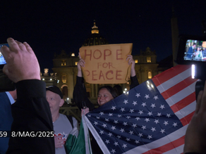 Yona Tukuser holds a "HOPE FOR PEACE" sign in St. Peter's Square at the Vatican during the Conclave
