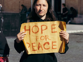Yona Tukuser holds a "HOPE FOR PEACE" sign in St. Peter's Square at the Vatican during the Conclave