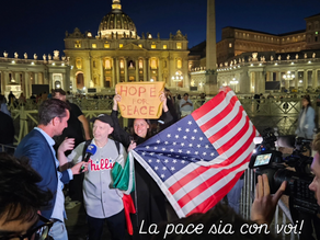 Yona Tukuser holds a "HOPE FOR PEACE" sign in St. Peter's Square at the Vatican during the Conclave