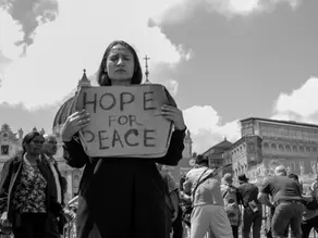 Yona Tukuser holds a "HOPE FOR PEACE" sign in St. Peter's Square at the Vatican during the Conclave