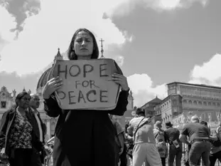 Yona Tukuser holds a "HOPE FOR PEACE" sign in St. Peter's Square at the Vatican during the Conclave