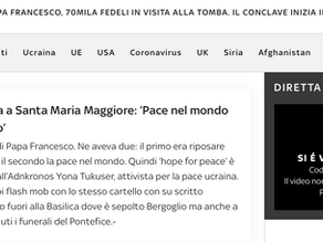 Yona Tukuser holds a "HOPE FOR PEACE" sign in St. Peter's Square at the Vatican during the Conclave