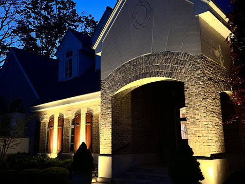 Warm white architectural accent lighting emphasizing exterior walls and architectural features on a Holland, MI residence.