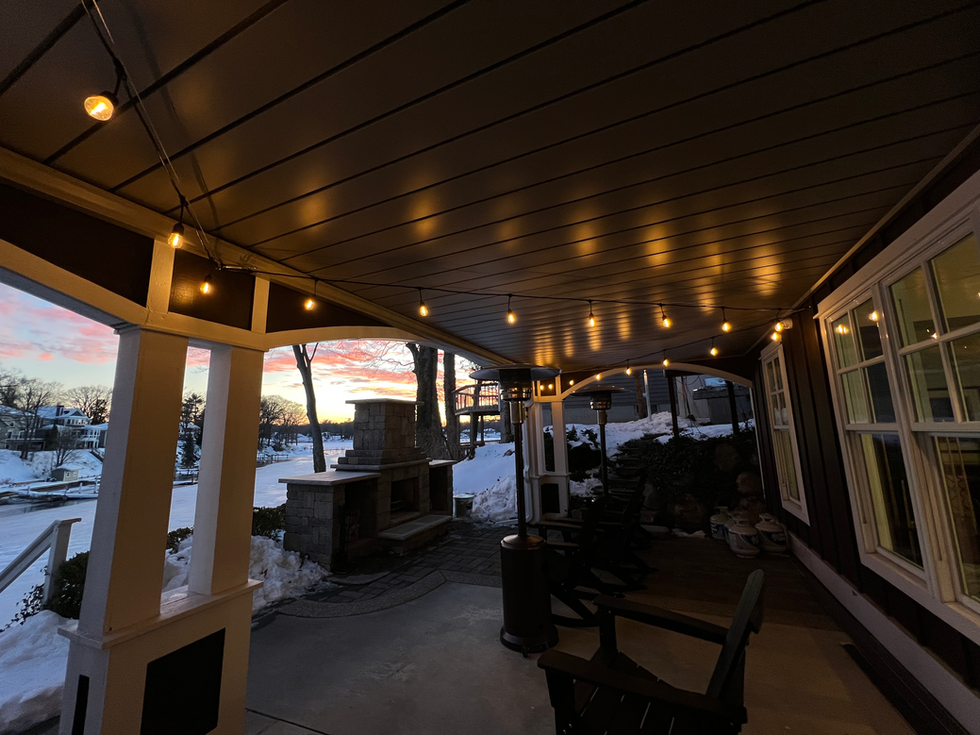Bistro lighting installation over a backyard patio with warm string lights in Holland, Michigan - Grand Rapids, Michigan.
