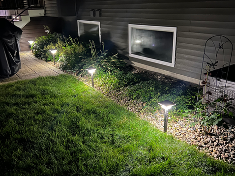 Garden lighting ideas illuminating a flower bed at night in Holland, Michigan - Grand Rapids, Michigan.