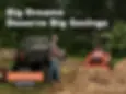 Man standing beside Kubota utility vehicle and compact tractor with front loader working on a dirt landscape during Kubota Orange Days sales event