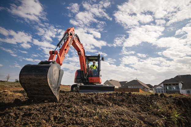Kubota compact excavator digging a trench at a residential construction site near Southern California