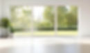 Clean interior room with a large three-panel white-framed window overlooking a bright green lawn and trees
